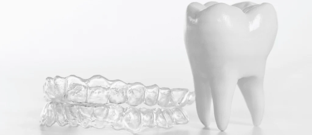 Clear aligner beside a tooth model